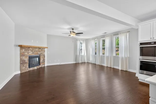 a view of a livingroom with wooden floor and a fireplace