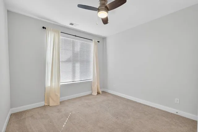 an empty room with closet and ceiling fan