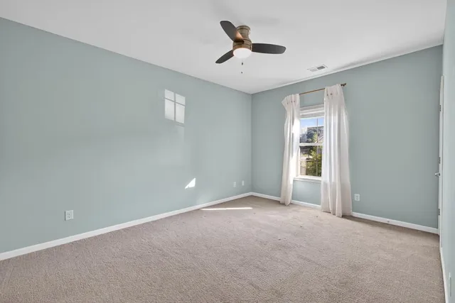 an empty room with a chandelier fan