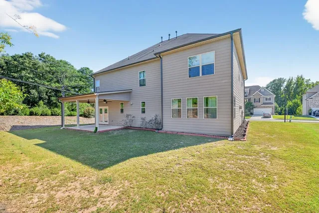 a view of a house with a yard and a tree