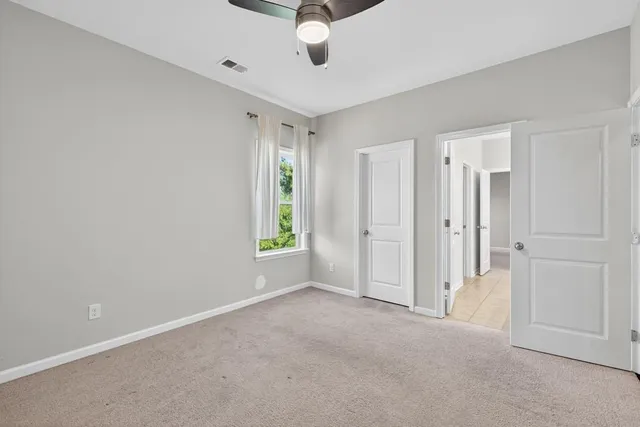 a view of a livingroom with a ceiling fan and window