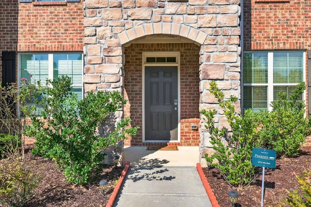 an empty room with wooden floor and windows with curtains
