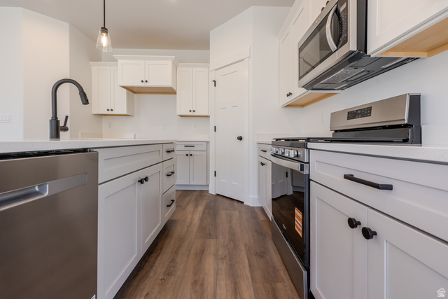 195 West Harmony Rdg Parkway, Unit 601 Mapleton, UT 84664 - Photo 8 of 23 Modern kitchen featuring white cabinetry, stainless steel appliances, wood-finish flooring, white countertops, and a black gooseneck faucet