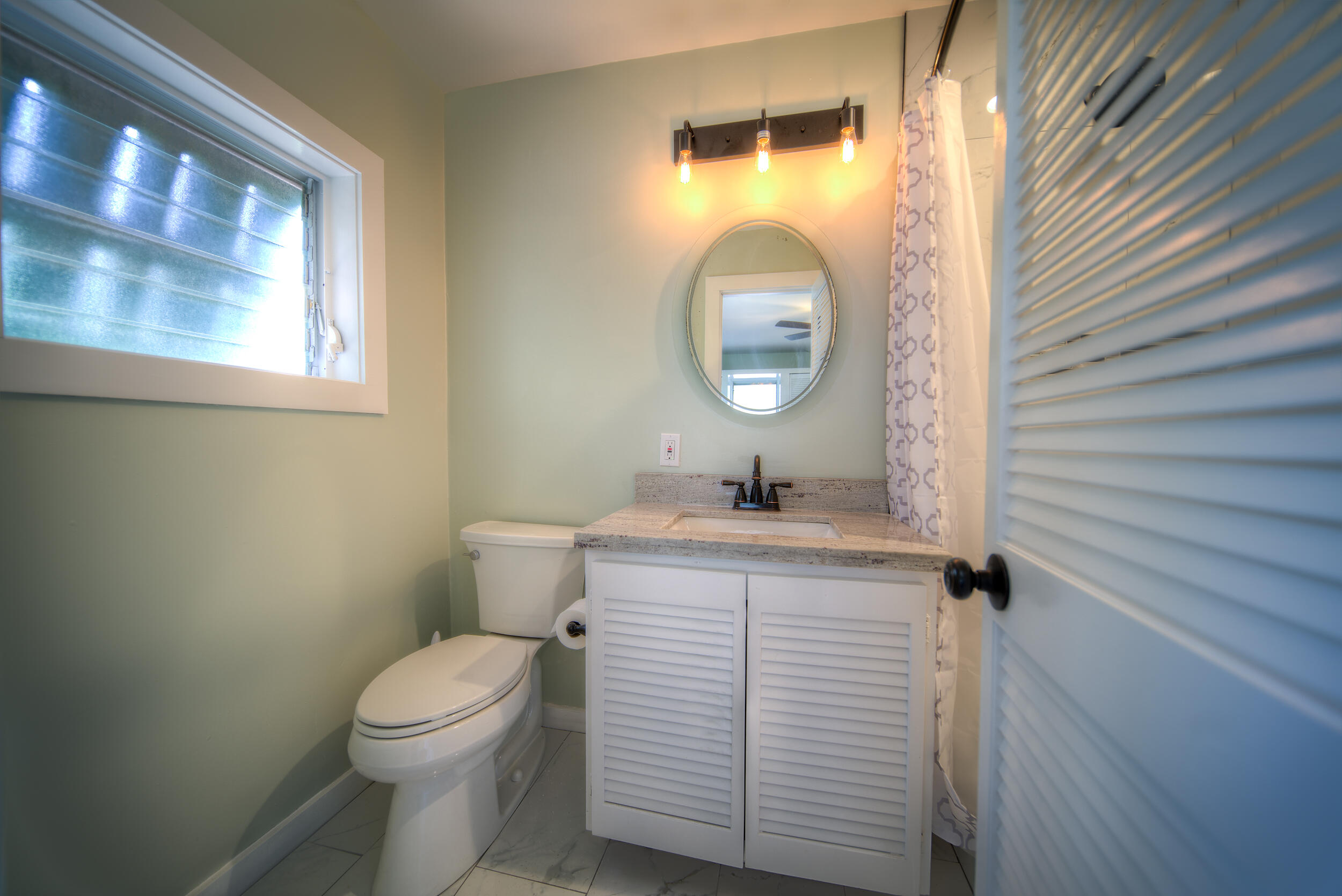 1317 Newton Street Key West, FL 33040 - Photo 12 of 19 a bathroom with a toilet a sink and mirror