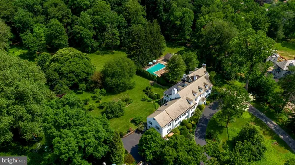 an aerial view of residential house with outdoor space and trees all around