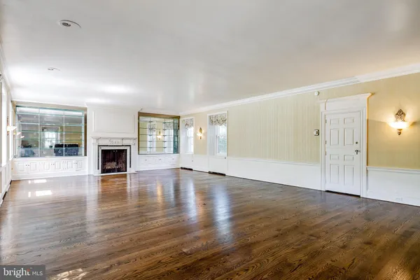 a view of empty room with wooden floor and fireplace