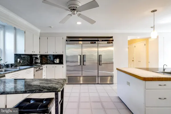 a kitchen with stainless steel appliances granite countertop a sink and a refrigerator
