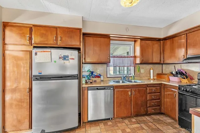 a kitchen with a sink appliances cabinets and a window