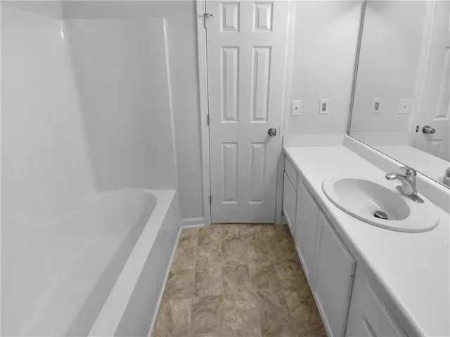 a bathroom with a sink a bathtub and a window