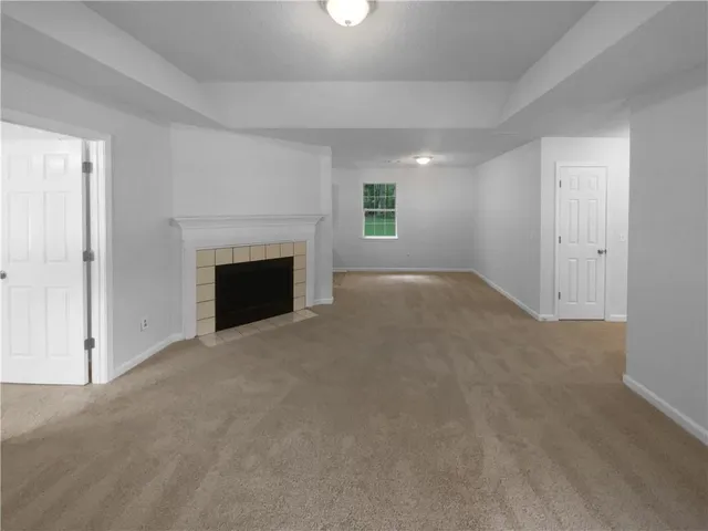an empty room with windows and fireplace