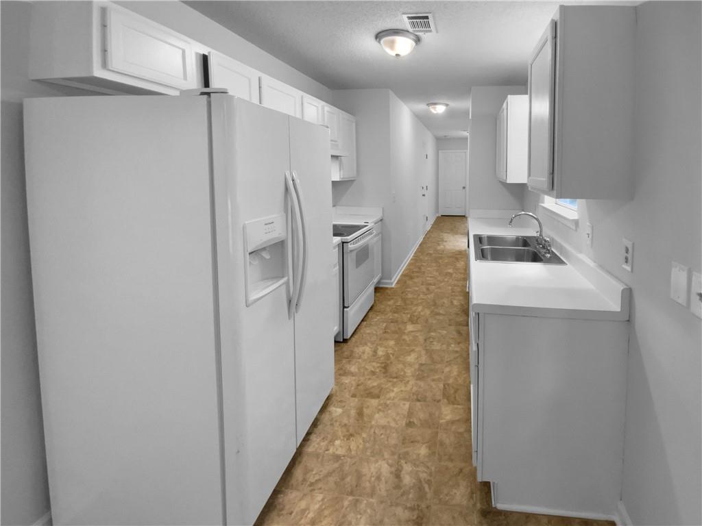 230 Myrtle Grove Lane Covington, GA 30014 - Photo 7 of 19 a kitchen with white cabinets and refrigerator