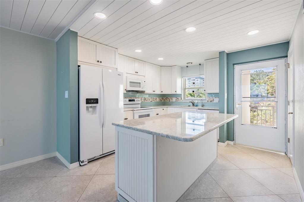 9 Haig Place, Unit 104 Dunedin, FL 34698 - Photo 6 of 59 a kitchen with a sink a stove a refrigerator and a sink
