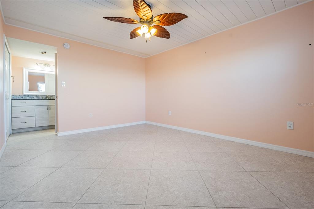 9 Haig Place, Unit 104 Dunedin, FL 34698 - Photo 9 of 59 an empty room with a chandelier fan and windows