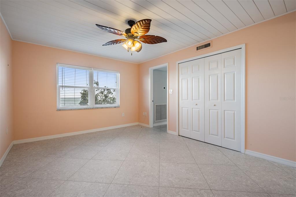 9 Haig Place, Unit 104 Dunedin, FL 34698 - Photo 10 of 59 an empty room with chandelier fan and windows