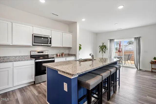 a kitchen with granite countertop kitchen island wooden cabinets and stainless steel appliances