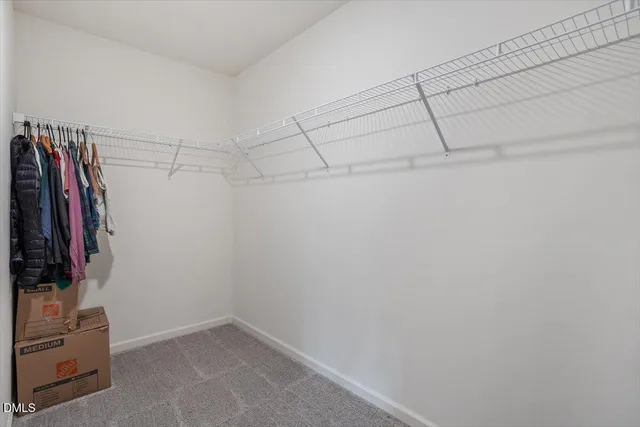 a view of walk in closet with clothes