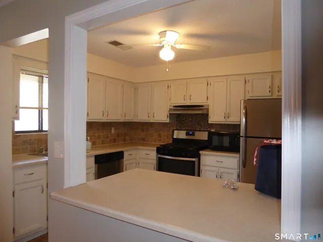 a kitchen with stainless steel appliances a stove refrigerator sink and microwave