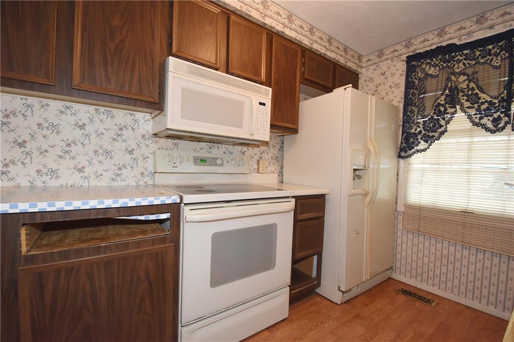 32 Shadow Drive Pittsburgh, PA 15227 - Photo 8 of 24 a kitchen with stainless steel appliances granite countertop a refrigerator a stove and a microwave with wooden floor