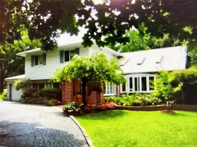 a front view of a house with a yard garage and outdoor seating