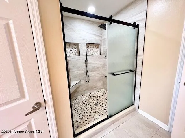a bathroom with a glass door shower and a sink