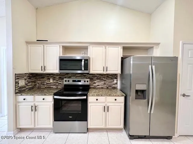 a kitchen with stainless steel appliances a stove a refrigerator and a microwave