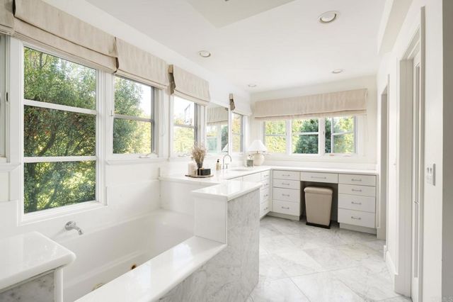 a bathroom with a tub sink and window