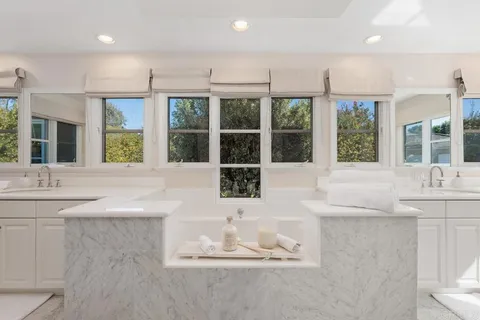 a bathroom with a tub sink and mirror