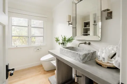 a bathroom with a granite countertop sink a toilet and shower
