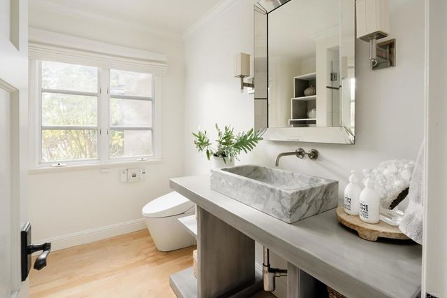 a bathroom with a granite countertop sink a toilet and shower