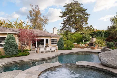 a view of a house with pool and sitting area