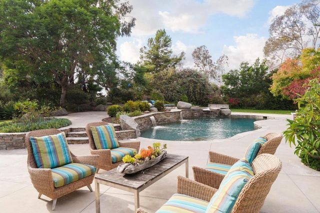 a view of swimming pool with outdoor seating and plants