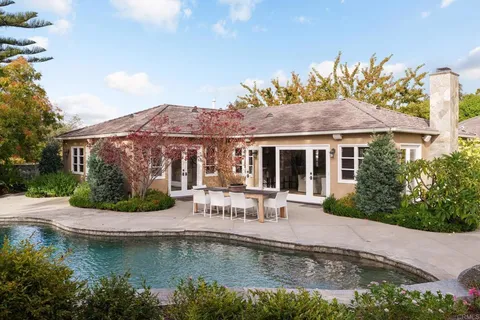 a front view of a house with swimming pool and a yard