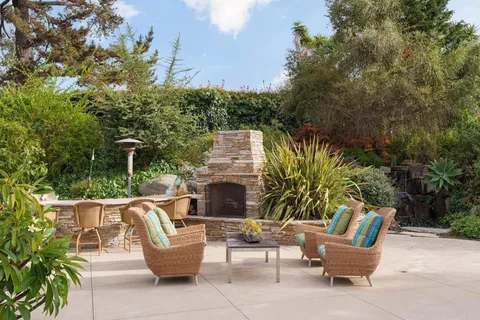 a view of a patio with couches and a potted plant on a table and chairs