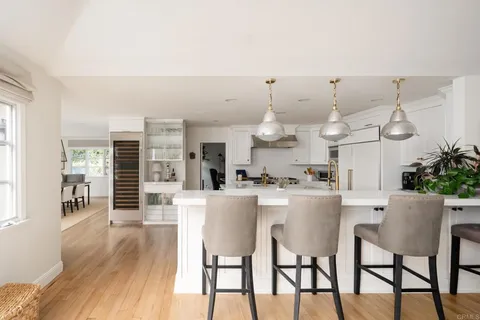 a kitchen with a dining table chairs and wooden floor