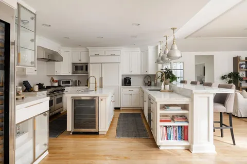 a kitchen with white cabinets and appliances