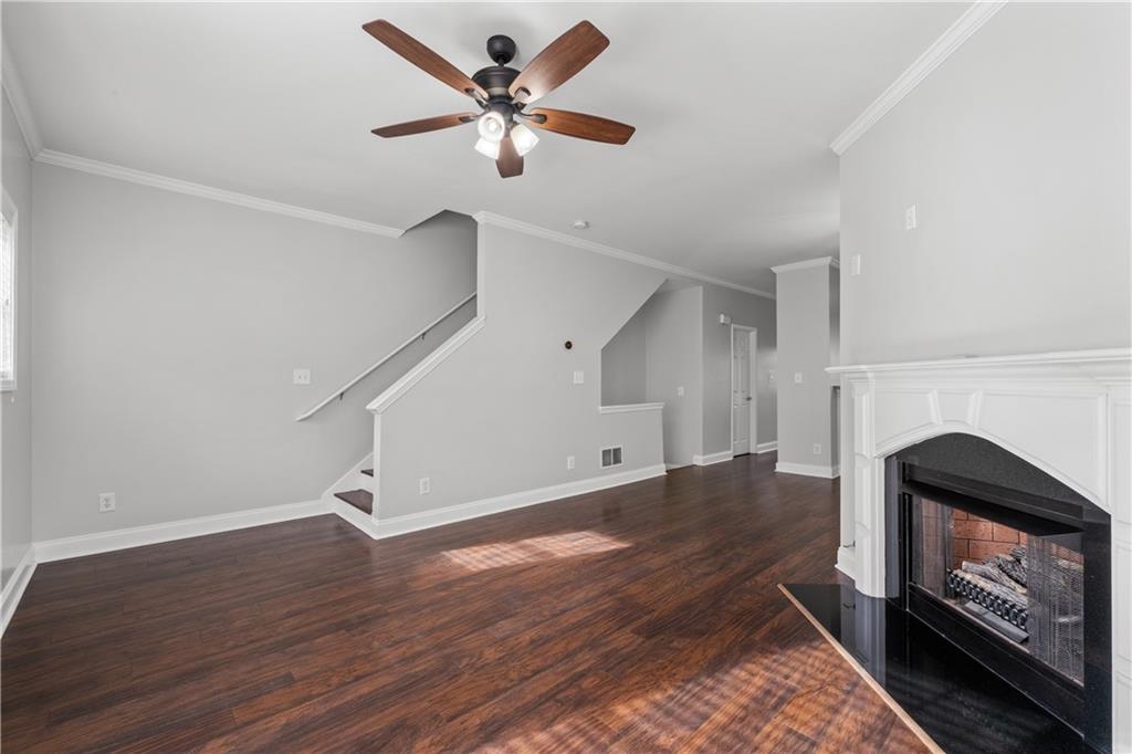 3072 Lauren Parc Road Decatur, GA 30032 - Photo 24 of 36 an empty room with wooden floor a ceiling fan a fireplace and windows