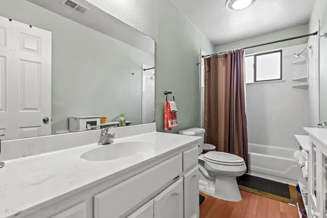 a bathroom with a sink a toilet a mirror and shower