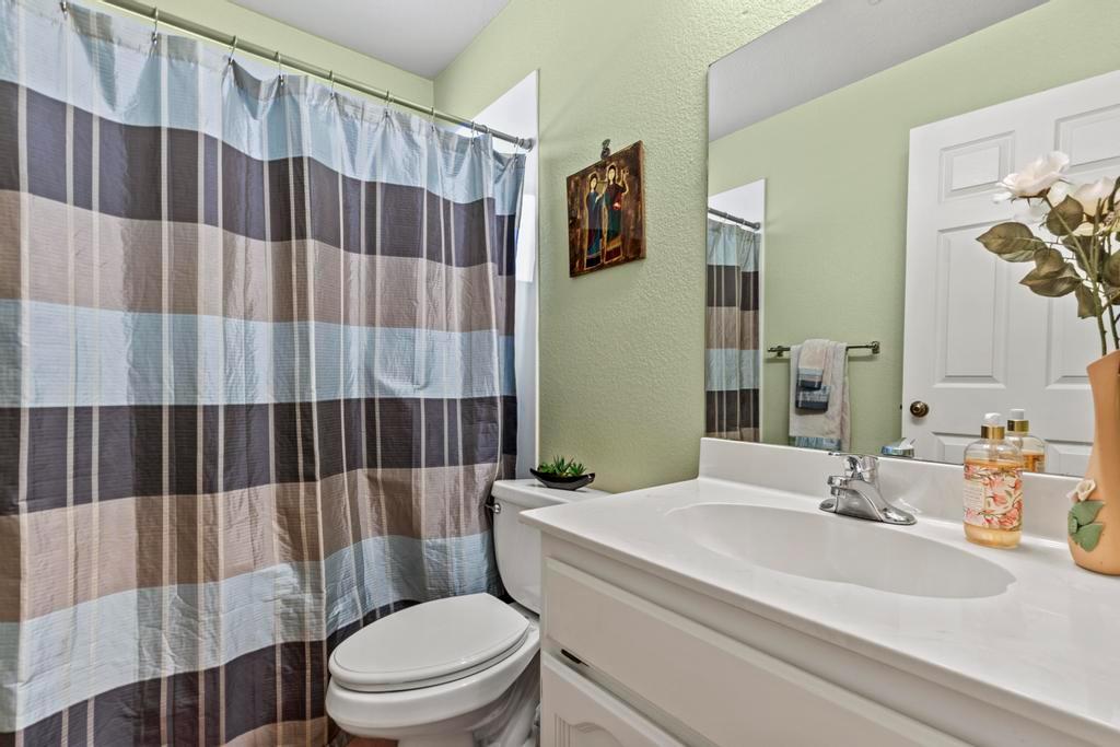13467 Lake Francis Road Dobbins, CA 95935 - Photo 35 of 54 a bathroom with a sink a toilet and shower curtain