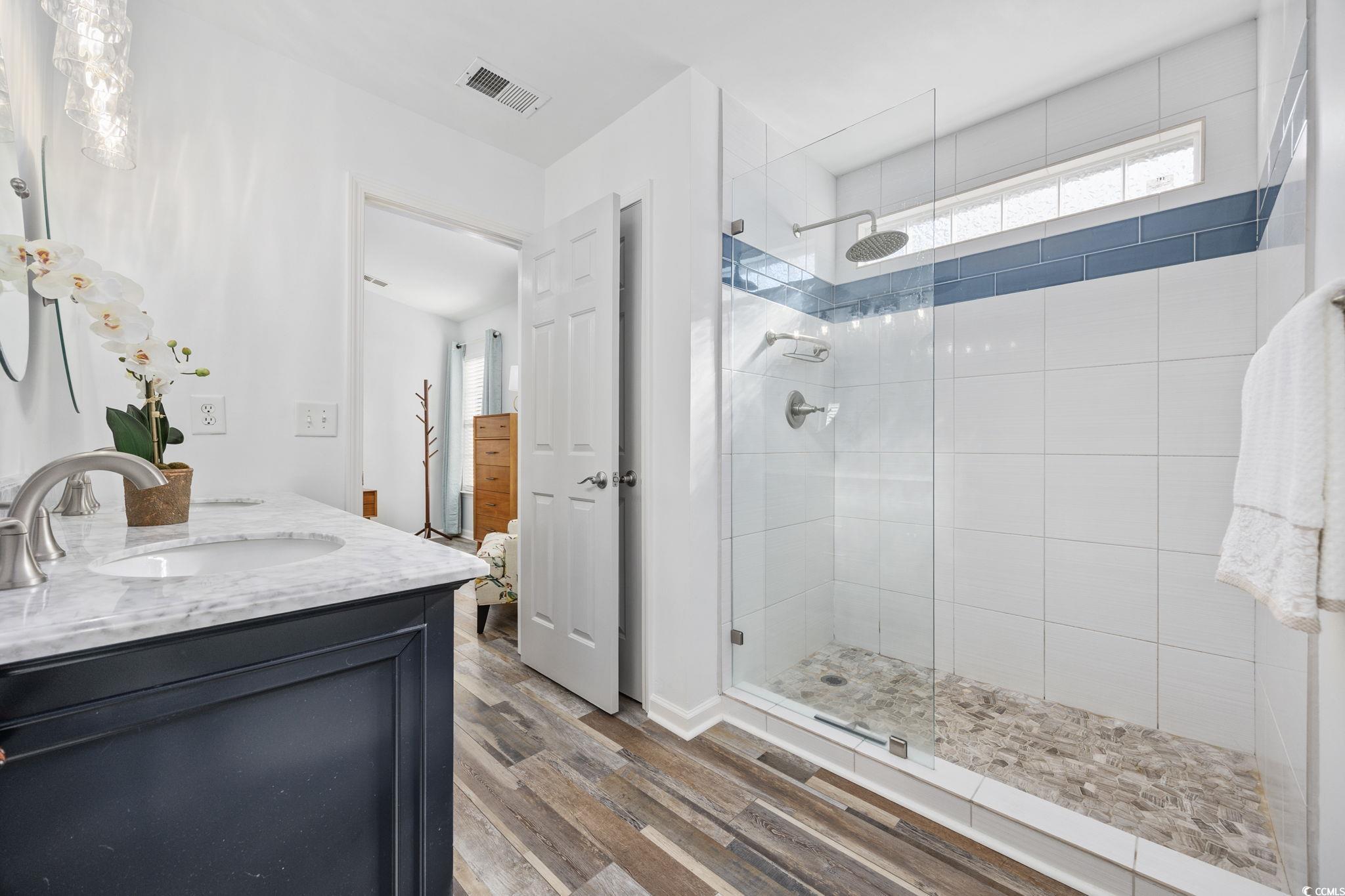 4618 Fringetree Drive Murrells Inlet, SC 29576 - Photo 16 of 40 Full bathroom featuring a walk in shower, ensuite bath, double vanity, and wood finished floors