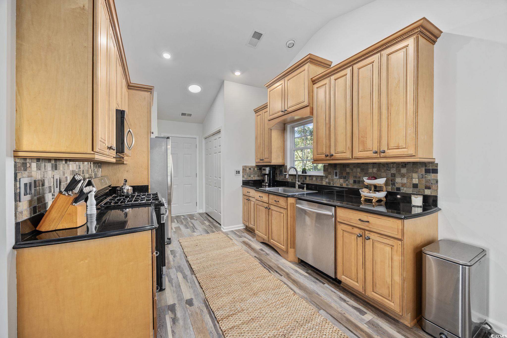 4618 Fringetree Drive Murrells Inlet, SC 29576 - Photo 7 of 40 Kitchen with decorative backsplash, stainless steel appliances, dark stone counters, recessed lighting, and light wood-style floors