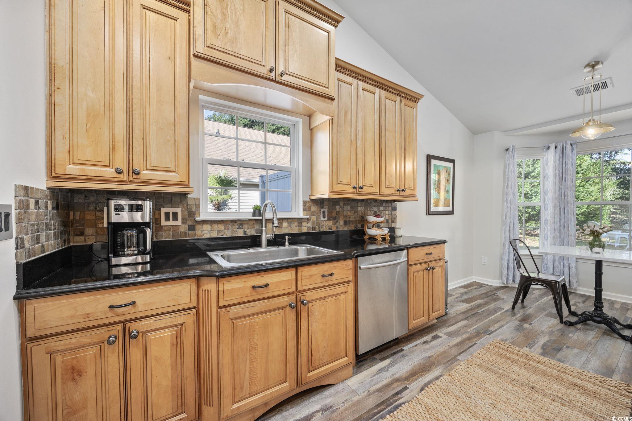 4618 Fringetree Drive Murrells Inlet, SC 29576 - Photo 9 of 40 Kitchen featuring backsplash, vaulted ceiling, dishwasher, light wood-style flooring, and dark stone counters