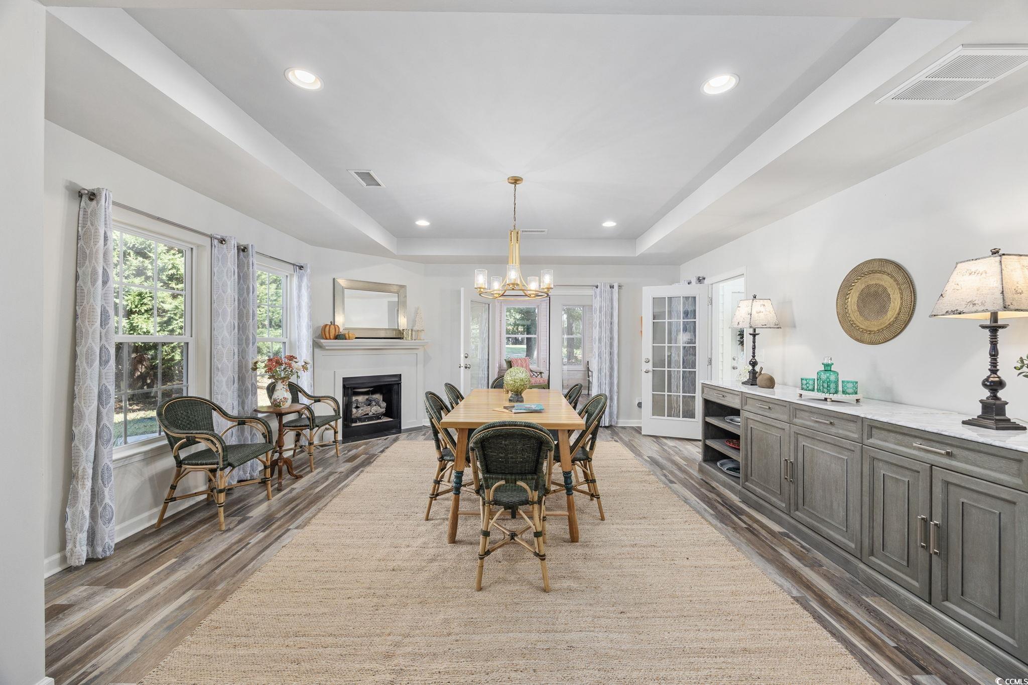 4618 Fringetree Drive Murrells Inlet, SC 29576 - Photo 10 of 40 Dining area featuring a raised ceiling, healthy amount of natural light, recessed lighting, and a fireplace