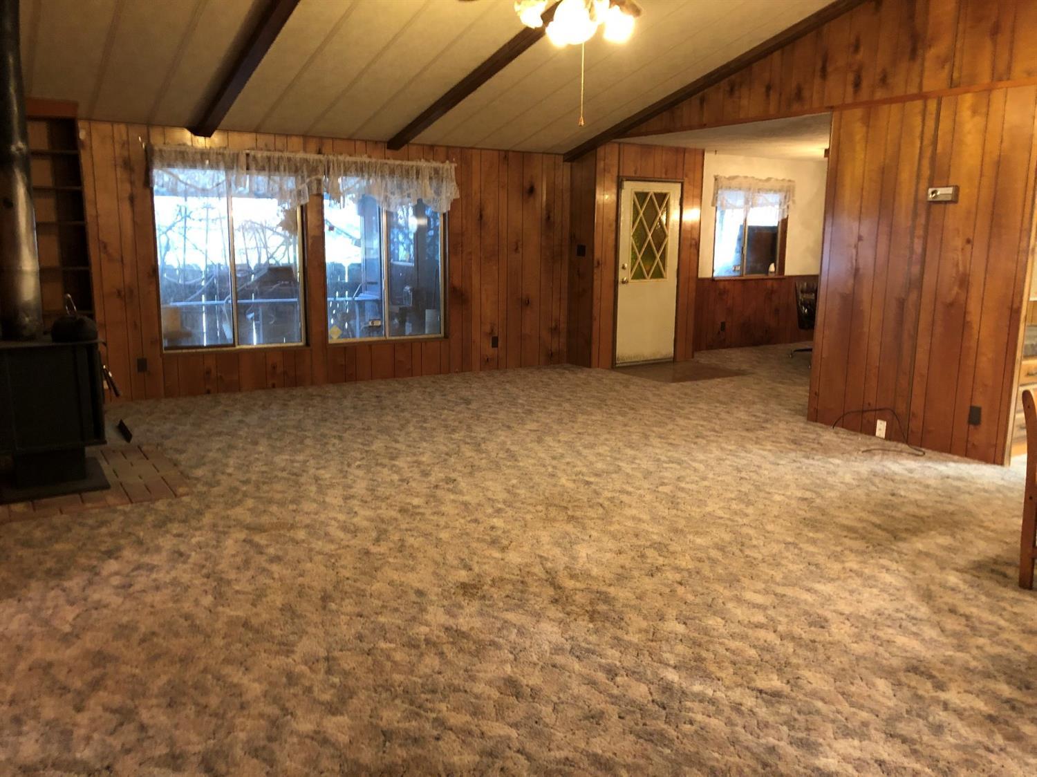 6226 East Evans Creek Road, Unit 15 Rogue River, OR 97537 - Photo 11 of 30 an empty room with chandelier fan and windows
