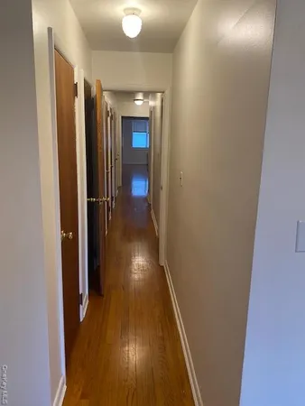 a view of a room with wooden floor and a bathroom