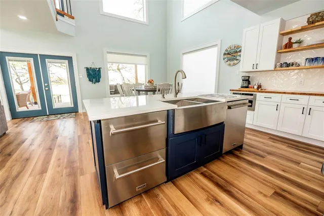 a kitchen with kitchen island a sink stainless steel appliances and cabinets