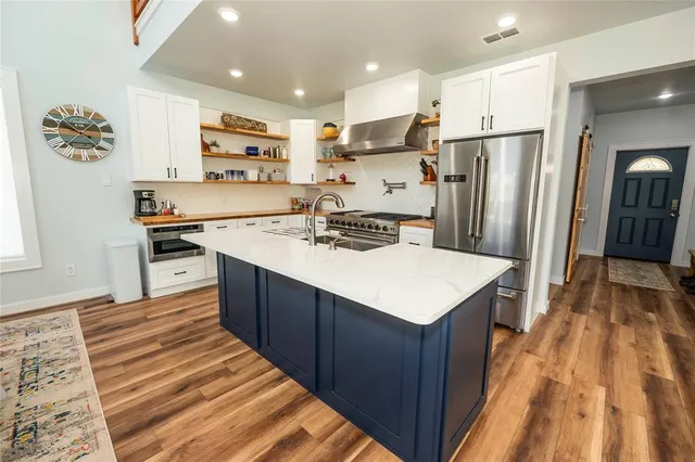 a kitchen with stainless steel appliances granite countertop a refrigerator stove and sink