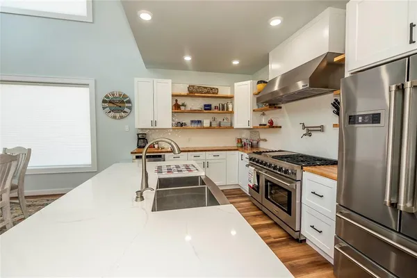 a large kitchen with stainless steel appliances granite countertop a stove oven and a refrigerator