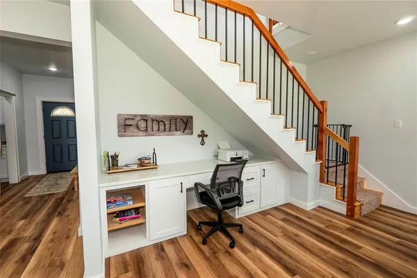 a living room with stainless steel appliances granite countertop furniture wooden floor and a large window