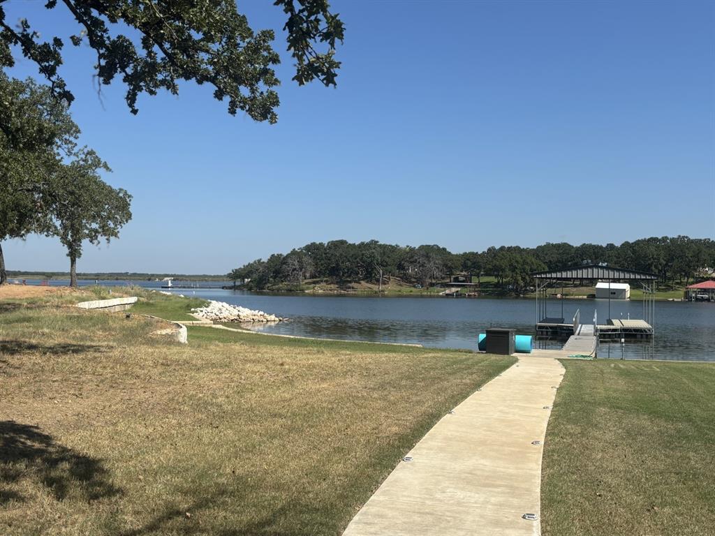 1529 Casino Road Nocona, TX 76255 - Photo 31 of 35 a view of a lake with a yard and a large tree