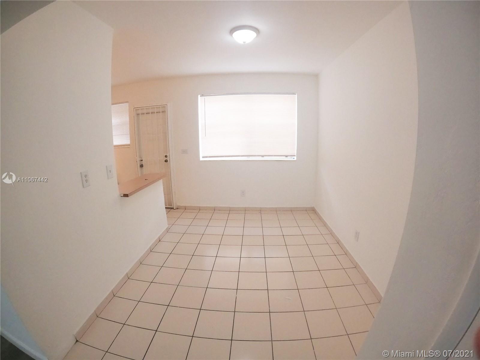 809 85th Street Miami Beach, FL 33141 - Photo 16 of 32 an empty room with white walls and tiles